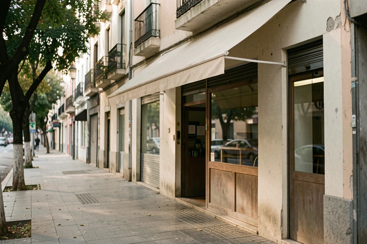 Empty neighbourhood café shopfront beside a tree-lined pavement