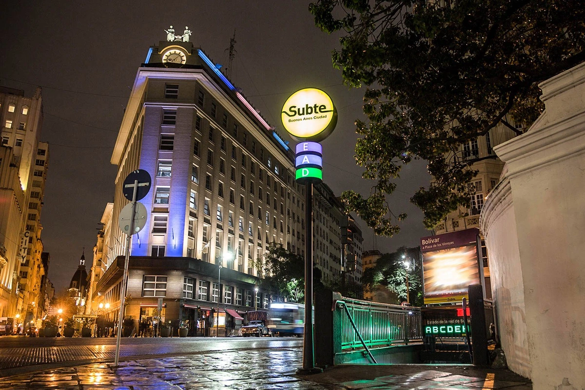 A Buenos Aires bus travelling along a broad avenue beside tree-lined pavements